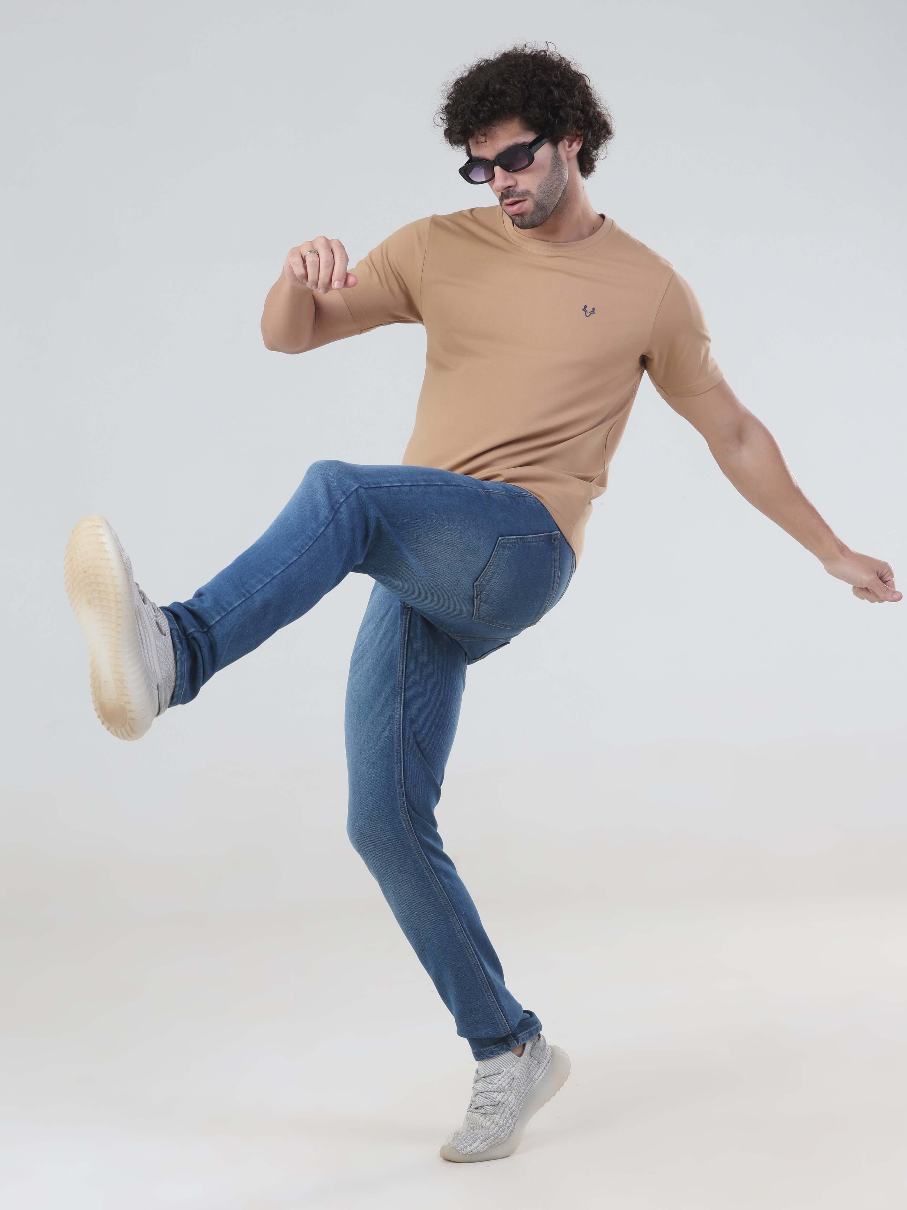Stylish man in desert brown T-shirt and jeans, showcasing a premium casual look with comfort and confidence.